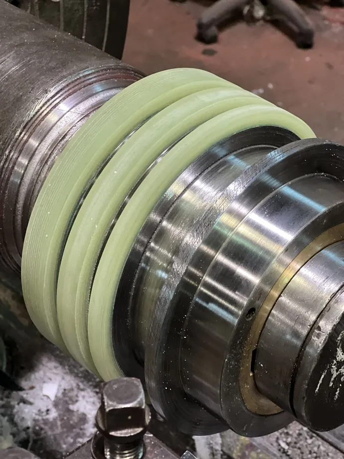 Grooved urethane roll cover cast on the shaft
